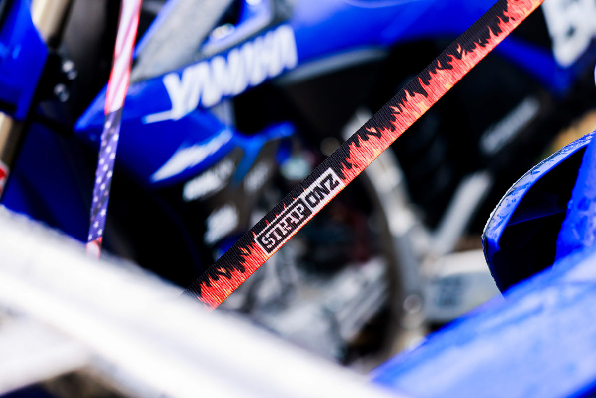 Strap Onz Retractable ratchet straps in use, holding down a dirt bike and a covered load on a ute tray